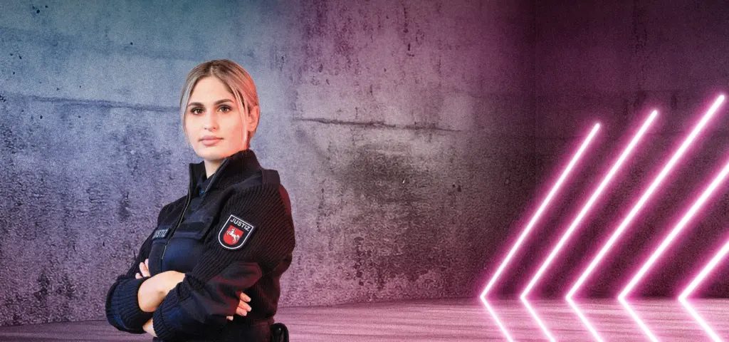 Eine Person in Justizdienstkleidung steht mit verschränkten Armen vor einer Betonwand mit blau-pinken Lichtverläufen. Rechts im Bild leuchten mehrere diagonale Neonlichtstreifen. Die Szene wirkt modern und selbstbewusst.